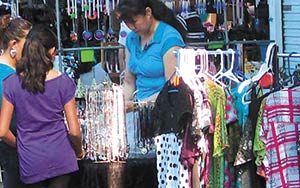 Woman and girls shopping at market for clothing